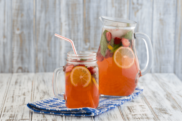 Healthy and fruity iced sun tea in a mug and pitcher for summer.