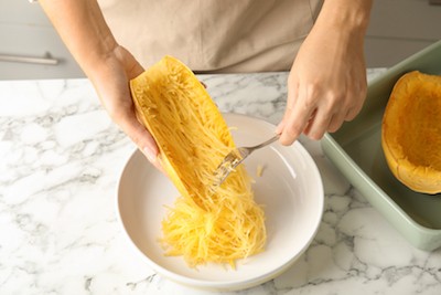 5 Sneaky Ways to Get Your Kids to Eat Their Veggies | St. Luke's Health A person scrapes cooked spaghetti squash out of the skin.