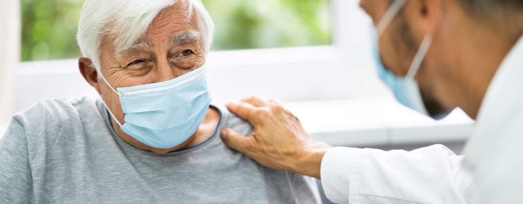 A urologist speaks with an elderly male patient.