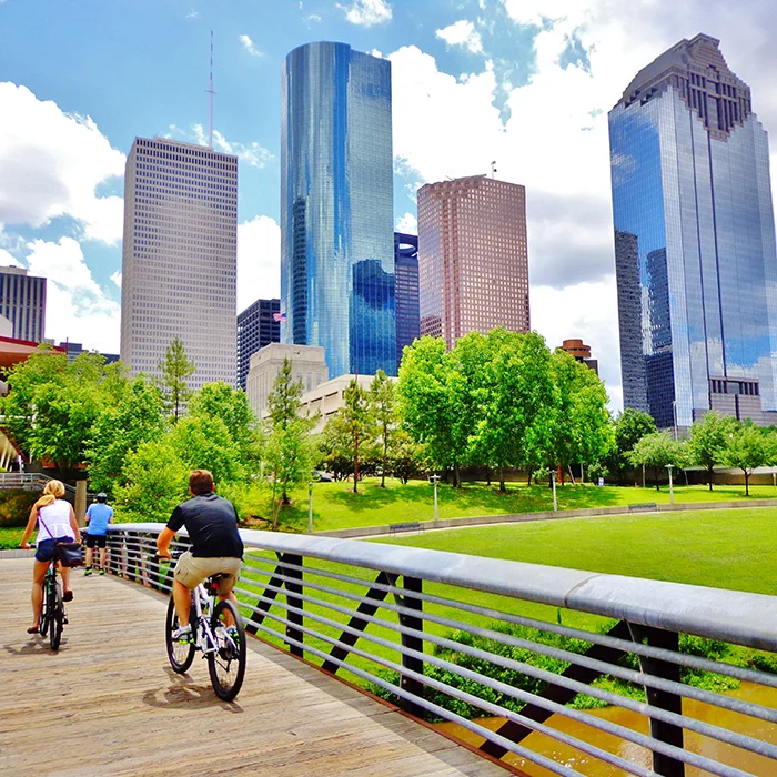 Two bike riders on a bridge in Houston.