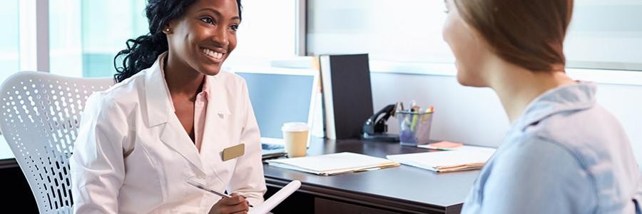 Smiling doctor talks to female patient