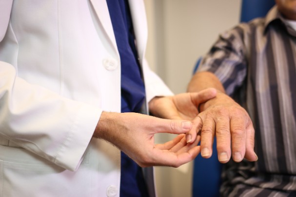 A doctor helps a patient move their hand.